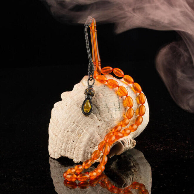 سبحة كهرمان مقطعة على شكل حبة شعير وعصير برتقال